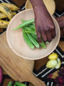 african woman chopping okra fruit overhead